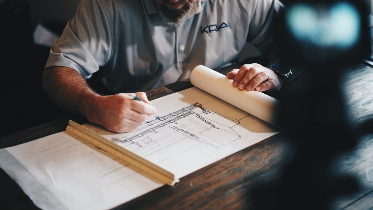 architect at drafting table with plans in front of them